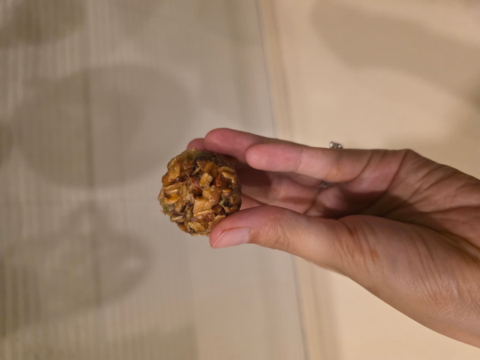 Hand holding a single NutriHome energy bomb close-up